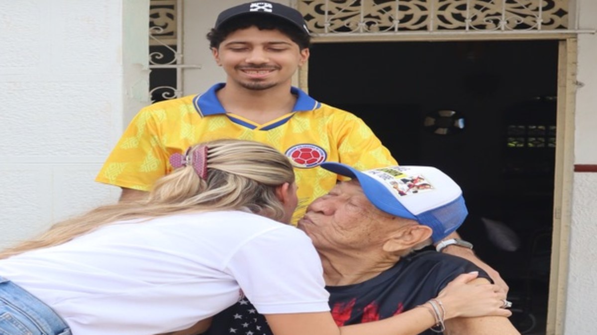 Una voluntaria abraza a una señora en la puerta de su casa durante una entrega de la Fundación